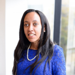Haben Girma, wearing a blue lace shirt and a pearl necklace, smiling Haben Girma, wearing a blue lace shirt and a pearl necklace, smiling